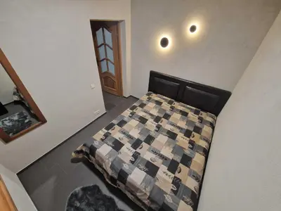 a bedroom with a bed with a checkered blanket at Gardenvillage house in Daržininkai
