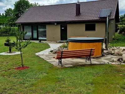 a bench in front of a house with a building at Gardenvillage house in Daržininkai