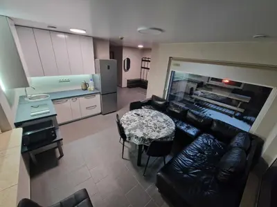 a living room with a couch and a table and a kitchen at Gardenvillage house in Daržininkai