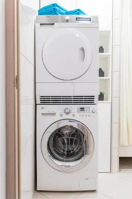a washer and dryer in a white room at Greimo Apartments in Šiauliai