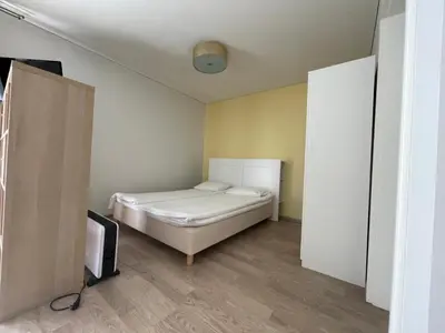 a small bedroom with a bed and a tv at PERLOS apartamentai 2a in Birštonas