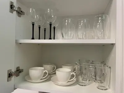 a shelf with wine glasses and cups and saucers at Avia Loft in Kaunas