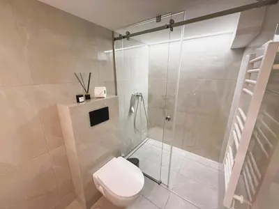 a bathroom with a toilet and a glass shower at Avia Loft in Kaunas