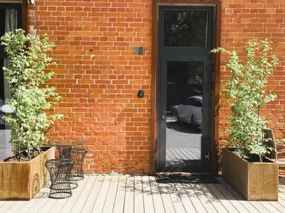 a brick building with a door and two plants at Avia Loft in Kaunas