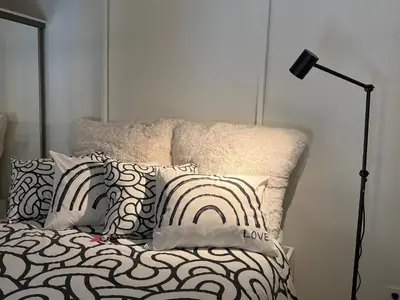 a bedroom with a bed with pillows and a lamp at Avia Loft in Kaunas