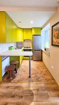 a kitchen with yellow cabinets and a white counter top at Green room in Šiauliai