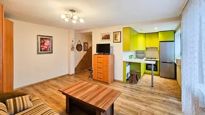 a living room with a table and a kitchen at Green room in Šiauliai