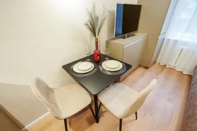 a dining room table with two chairs and a television at Stylish studios near the city center in Vilnius