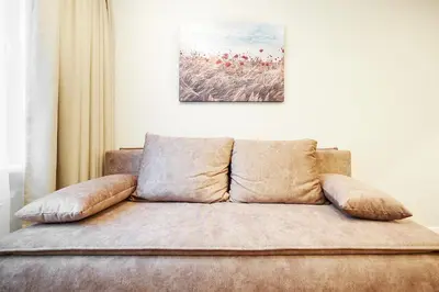 a couch with pillows sitting under a painting on the wall at Stylish studios near the city center in Vilnius