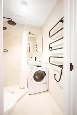a washing machine in a bathroom with a sink at Stylish studios near the city center in Vilnius