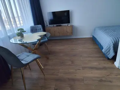 a room with a table and chairs and a bed at Itaja apartment 73 in Šiauliai