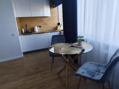 a small kitchen with a table and chairs in a room at Itaja apartment 73 in Šiauliai