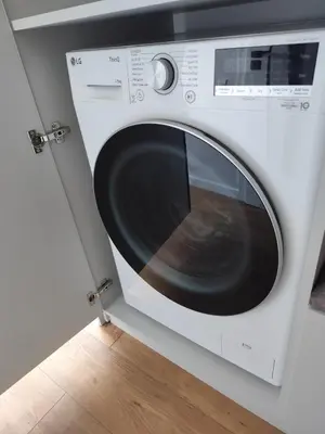 a white washing machine sitting in a room at Itaja apartment 73 in Šiauliai