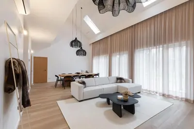 a living room with a white couch and a table at Picturesque Villa RestArt by Reside Baltic in Nemenčinė