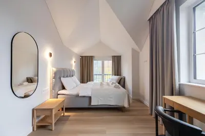 a hotel room with a bed and a mirror at Picturesque Villa RestArt by Reside Baltic in Nemenčinė