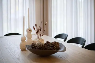 a bowl of pine cones and candles on a table at Picturesque Villa RestArt by Reside Baltic in Nemenčinė
