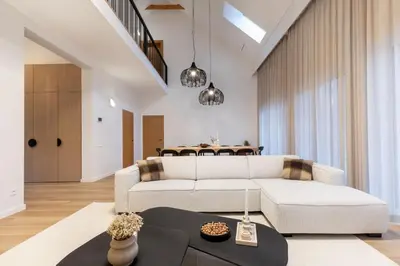 a living room with a white couch and a table at Picturesque Villa RestArt by Reside Baltic in Nemenčinė