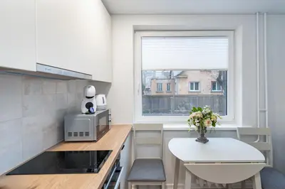 a small kitchen with a table and a window at Studio apartment Sea by PoloApartments in Kaunas