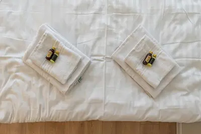 two white towels sitting on top of a bed at Studio apartment Sea by PoloApartments in Kaunas