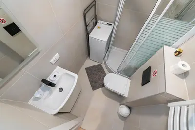 a small bathroom with a toilet and a sink at Studio Apartment Flora by PoloApartments in Kaunas