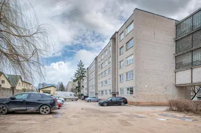 a parking lot with cars parked in front of a building at Studio Apartment Flora by PoloApartments in Kaunas