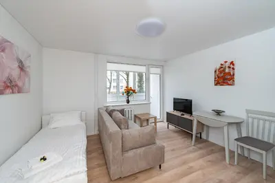 a bedroom with a bed and a chair and a desk at Studio Apartment Flora by PoloApartments in Kaunas