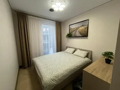 a small bedroom with a bed and a window at WAVE Apartaments Vilnius in Vilnius