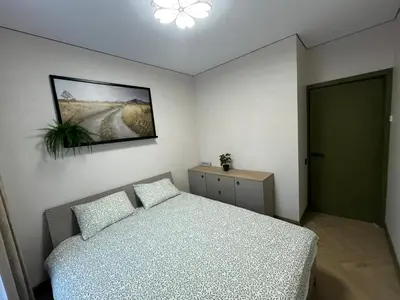a bedroom with a bed and a painting on the wall at WAVE Apartaments Vilnius in Vilnius