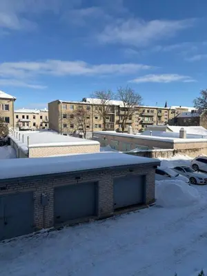 a building with two garage doors in the snow at Cosy little studio in Šiauliai