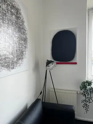 a living room with a black couch and a tv at Cosy little studio in Šiauliai