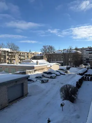 a parking lot covered in snow with cars parked at Cosy little studio in Šiauliai