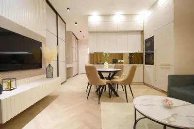 a kitchen and living room with a table and chairs at Vilniaus 99 Apartamentai in Šiauliai