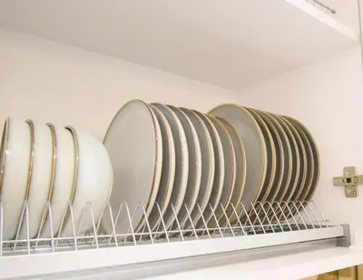 a row of plates on a shelf in a kitchen at Vilniaus 99 Apartamentai in Šiauliai