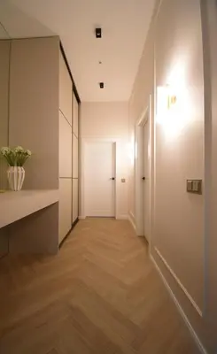 an empty hallway with a white door and wooden floors at Vilniaus 99 Apartamentai in Šiauliai