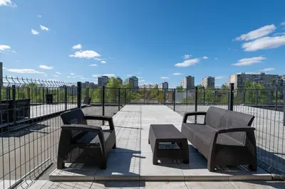 two chairs and a table on a balcony with a fence at Charlotte loft in Vilnius