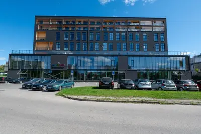 a large building with cars parked in a parking lot at Charlotte loft in Vilnius