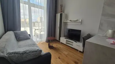 a living room with a flat screen tv and a couch at Charlotte loft in Vilnius