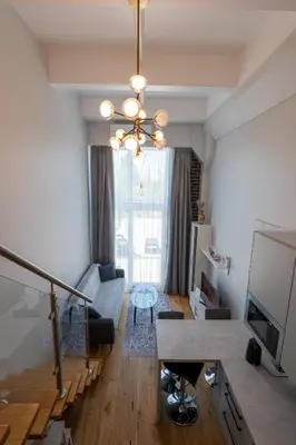a living room with a couch and a chandelier at Charlotte loft in Vilnius