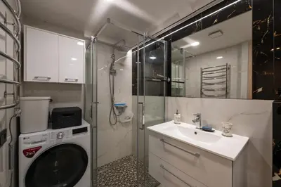 a bathroom with a washing machine and a sink at Charlotte loft in Vilnius