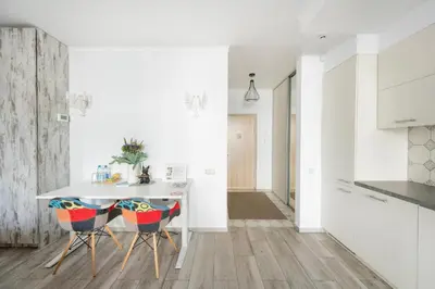 a kitchen with white walls and a table and chairs at Vincent Heritage Appartments - Near Clinic, Arena and Stadium in Kaunas
