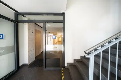 a hallway of a building with a door and stairs at Vincent Heritage Appartments - Near Clinic, Arena and Stadium in Kaunas