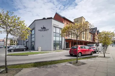 a red car parked in front of a building at Vincent Heritage Appartments - Near Clinic, Arena and Stadium in Kaunas
