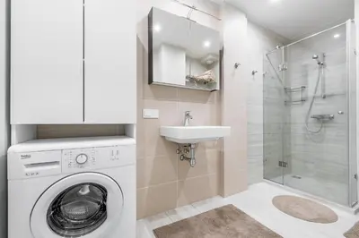 a bathroom with a washing machine and a sink at City center apartment, free parking, 149 in Vilnius