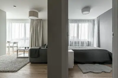 a bedroom with a bed and a couch and windows at City center apartment, free parking, 149 in Vilnius