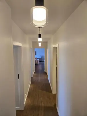 a hallway of an empty apartment with a light fixture at Panoramic balcony 3BD apt with king bed in Kaunas