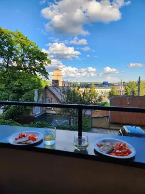 a table with two plates of food on a balcony at Panoramic balcony 3BD apt with king bed in Kaunas