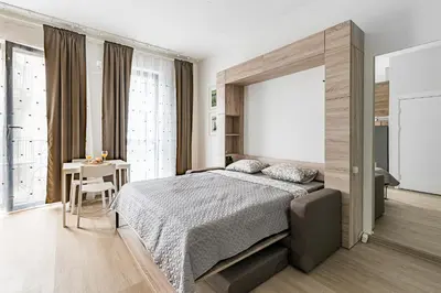 a bedroom with a large bed and a table at City center studio, 24 in Vilnius