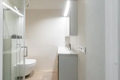 a white bathroom with a toilet and a sink at City center studio, 24 in Vilnius