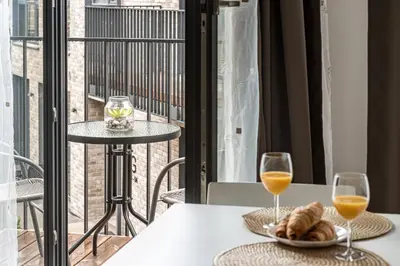 a table with two glasses of wine and a plate of food at City center studio, 24 in Vilnius