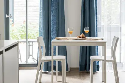 a table with two glasses of wine and a plate of food at City center studio, parking, 16 in Vilnius